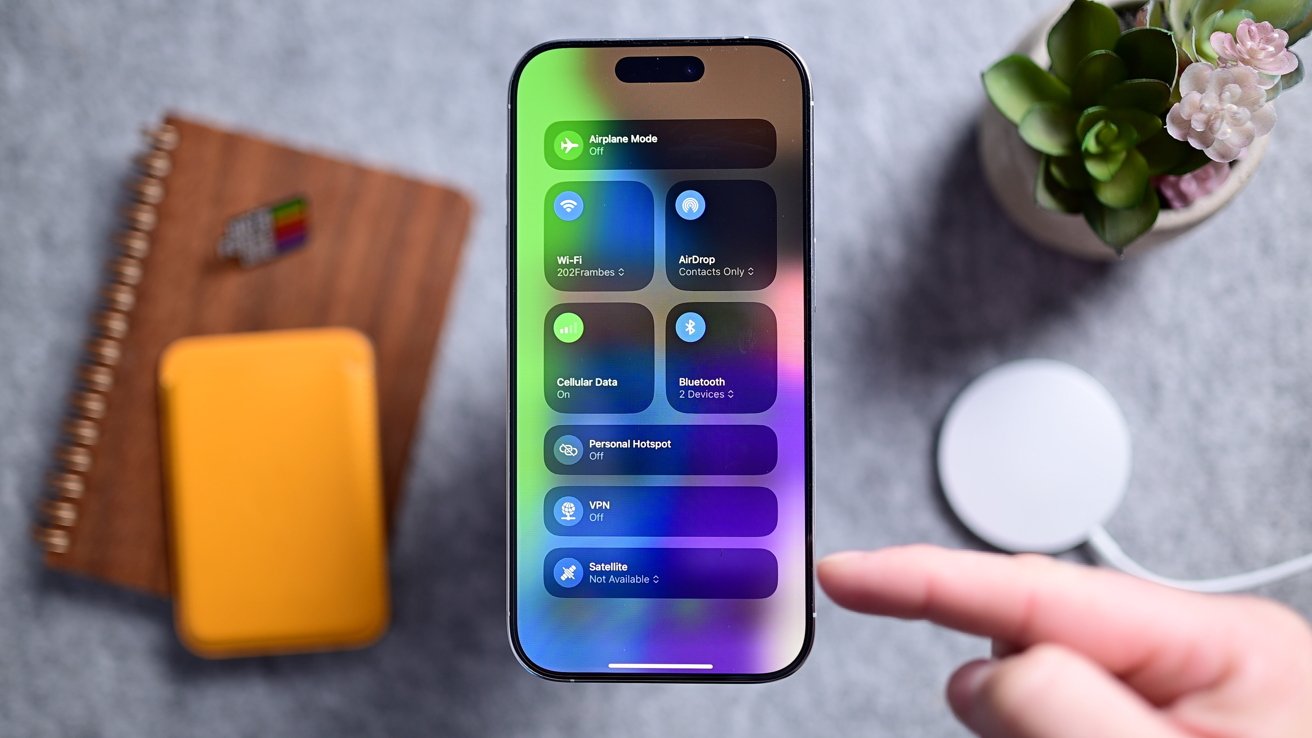 iPhone на сером столе с Центром управления и различными переключателями настроек и подключений